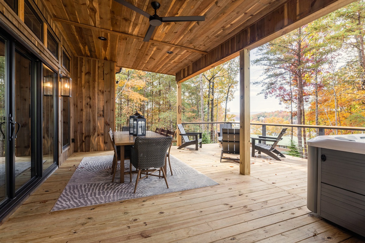 The covered deck offers a mix of seating options with stunning forest views and peaceful surroundings.