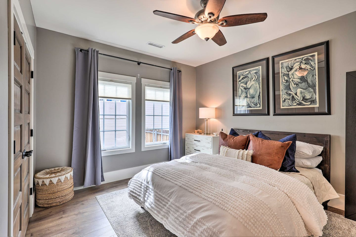 Rich wood tones and gallery art give this bedroom a warm, gathered-in feel.
