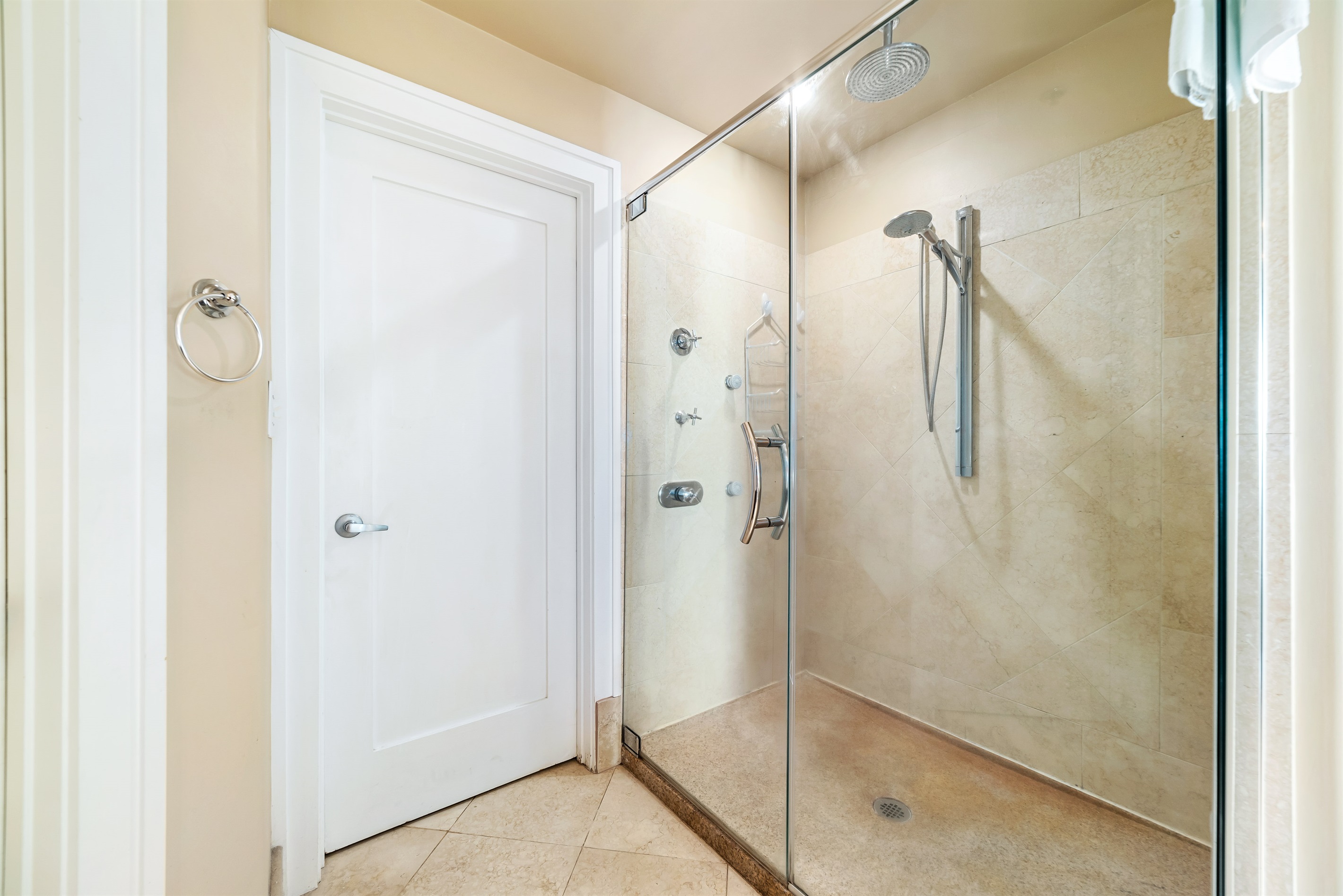 Featuring a sleek glass shower enclosure, a stylish vessel sink atop a rich wood vanity, and a large mirror amplifying the space, this bathroom blends functionality with modern aesthetics.