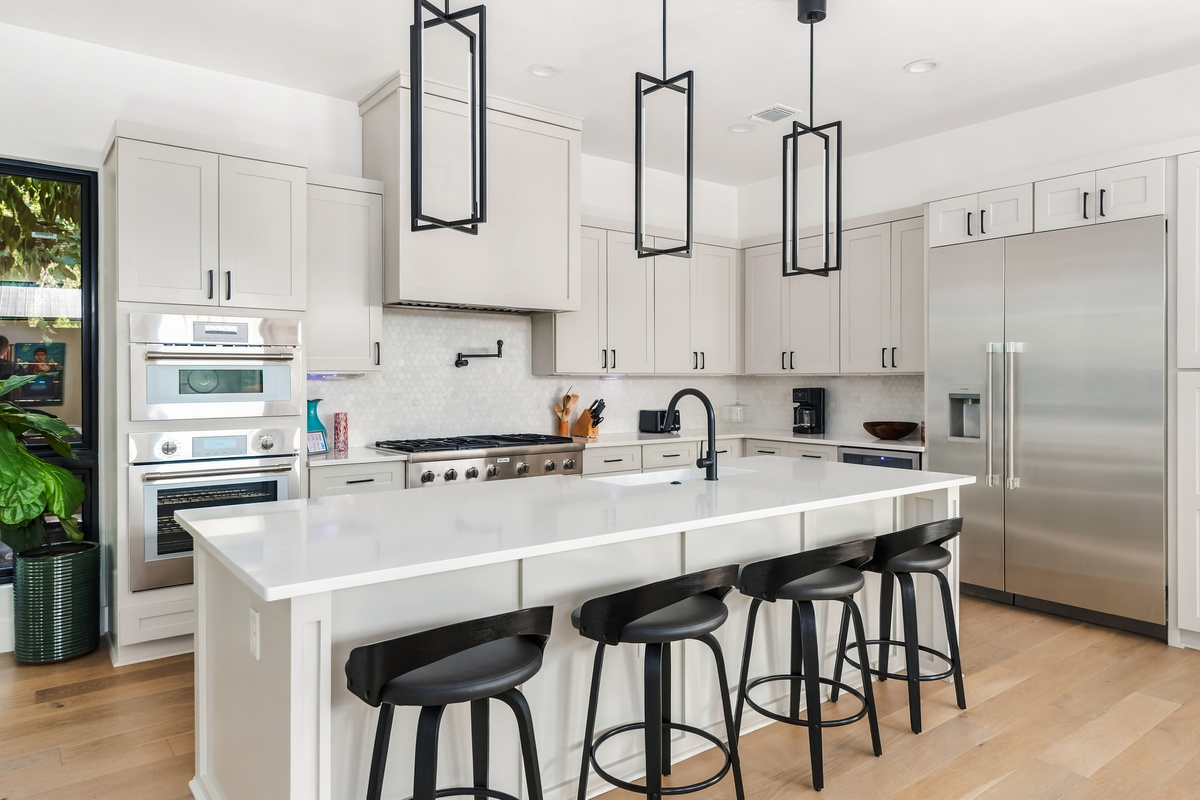 Sleek black bar stools line the island — a favorite gathering spot.