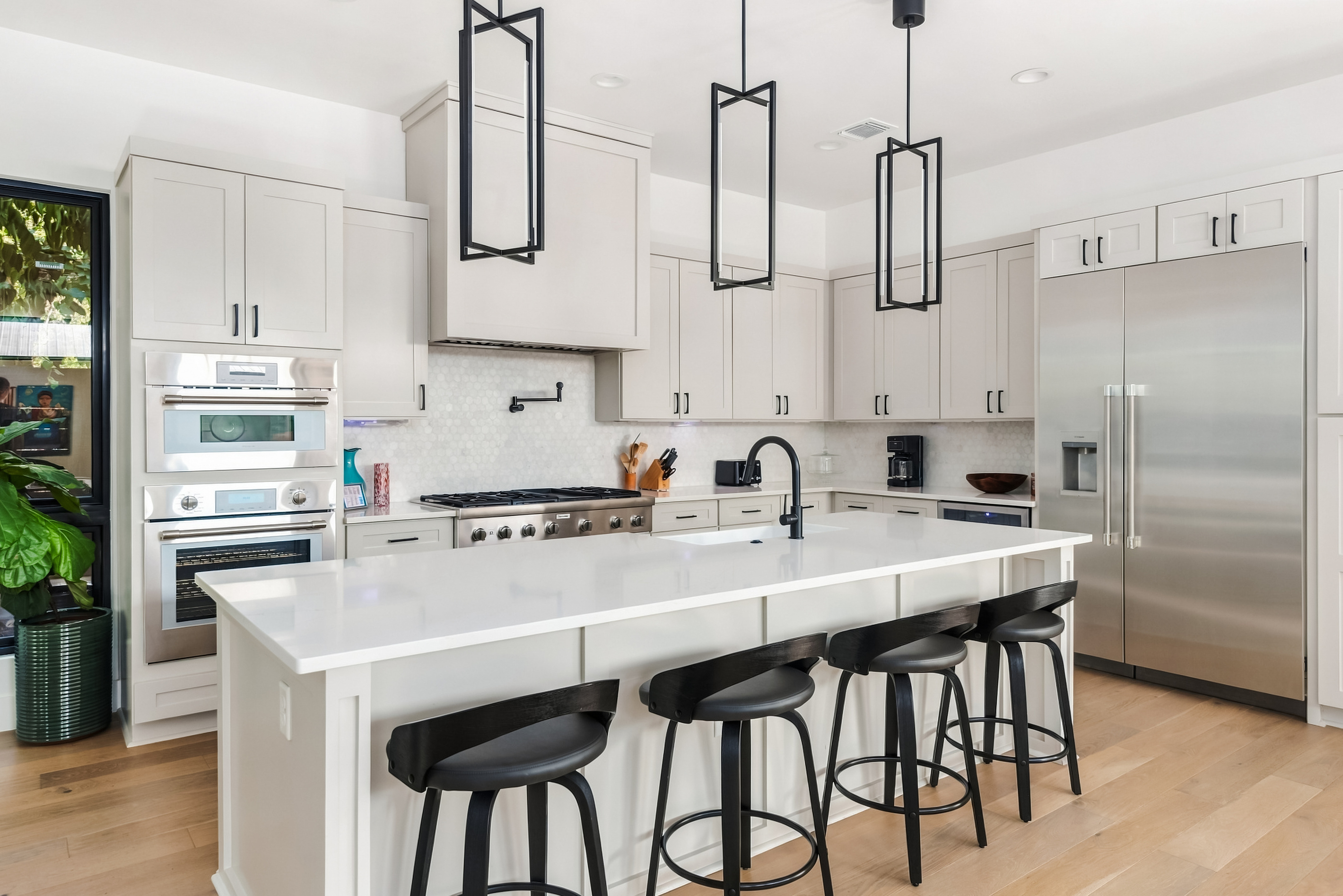 Sleek black bar stools line the island — a favorite gathering spot.