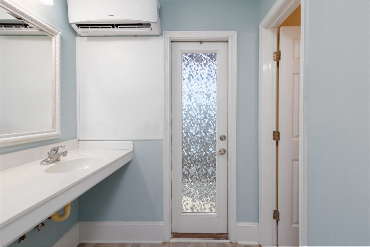 Light-filled bathroom with a frosted-glass door