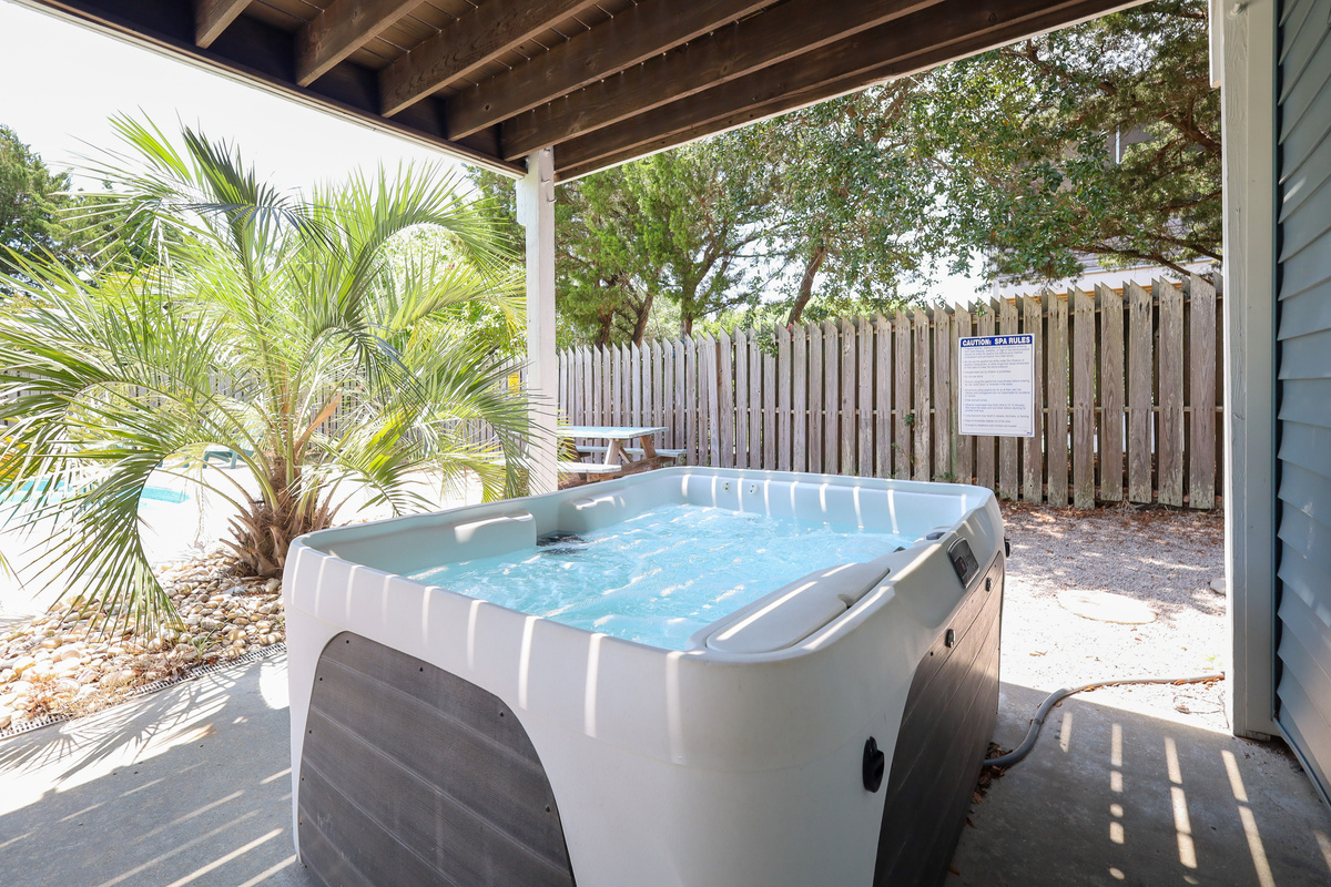 The private hot tub is tucked beneath the covered patio, creating a relaxing retreat any time of day