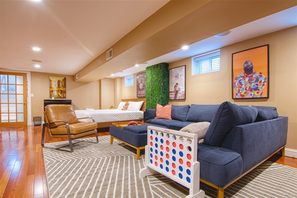 Large lounge sofa in lower floor suite with 65" TV, in-ceiling speakers