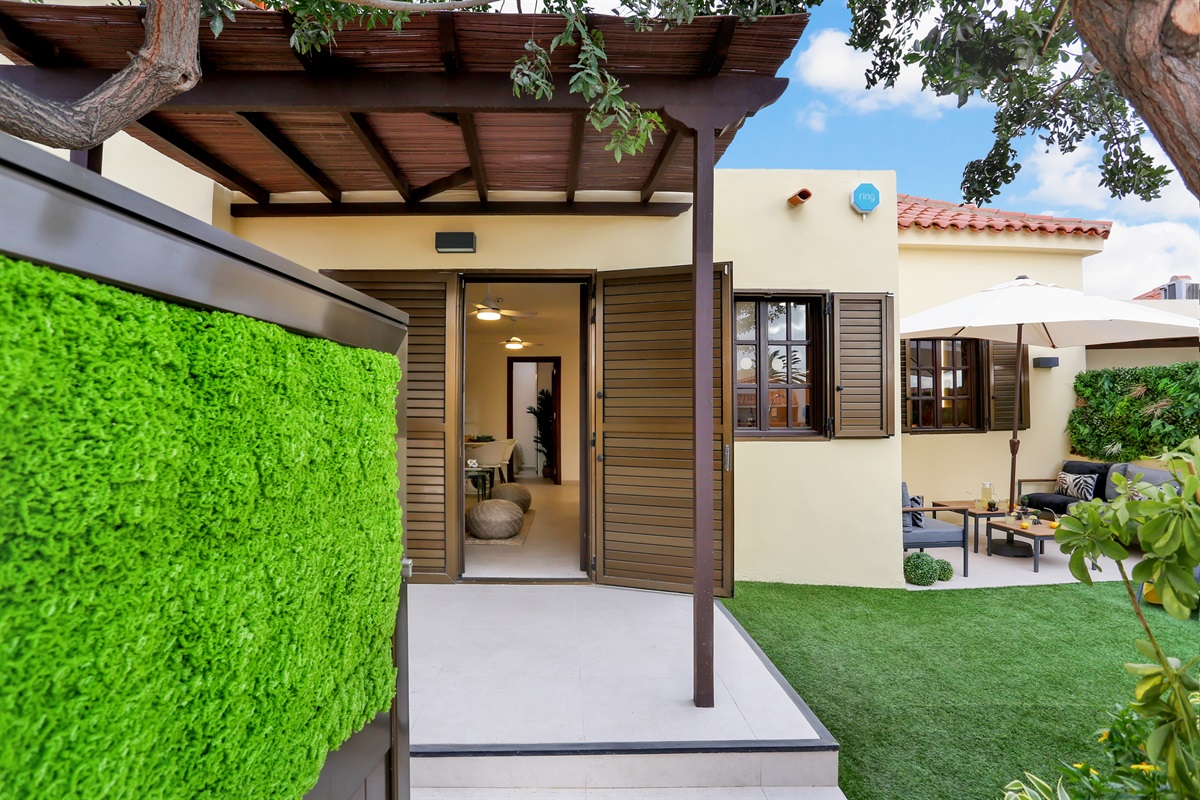 Entrance to the bungalow with a covered terrace and direct access to the private garden, an ideal space to enjoy the outdoors in total comfort.