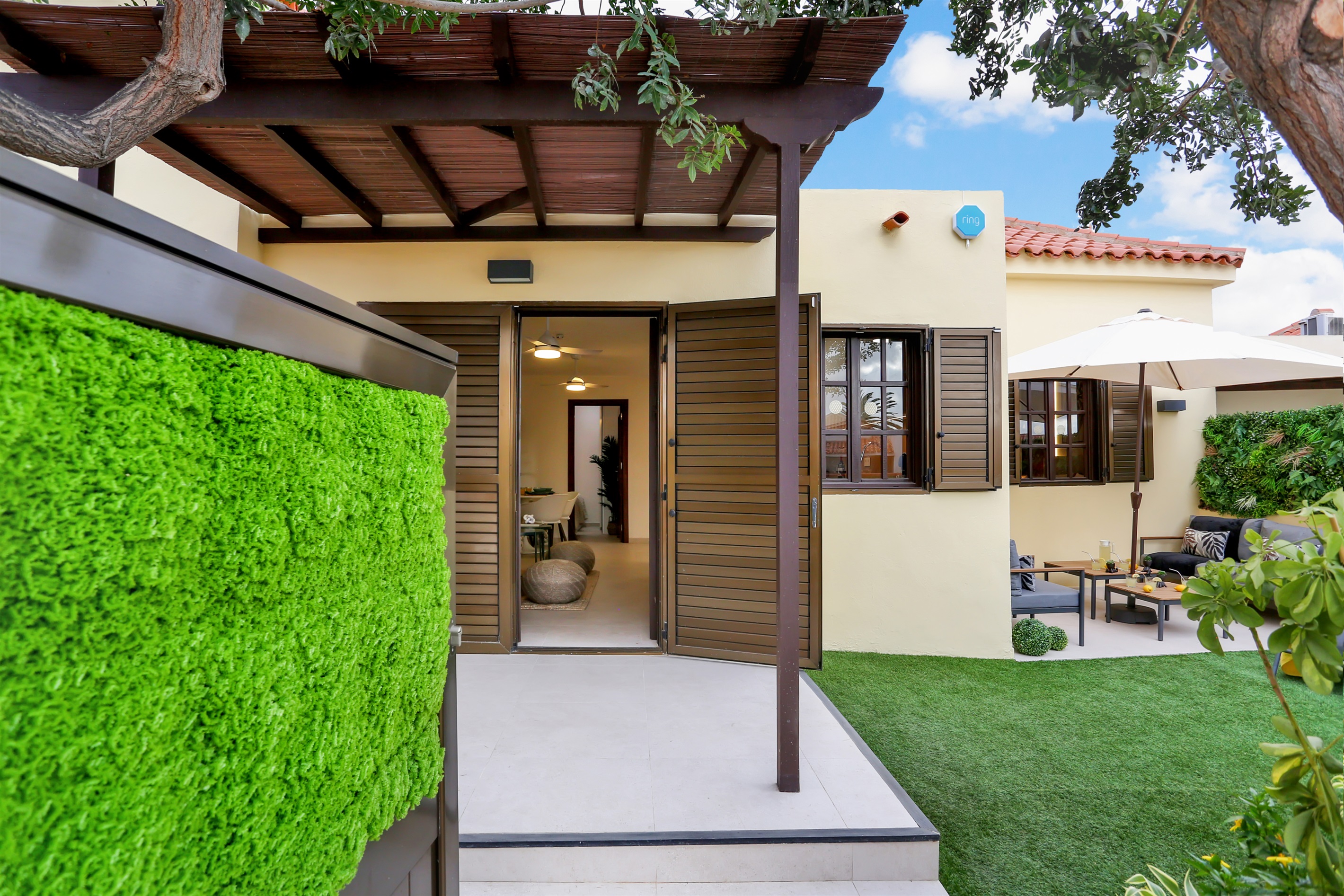 Entrance to the bungalow with a covered terrace and direct access to the private garden, an ideal space to enjoy the outdoors in total comfort.