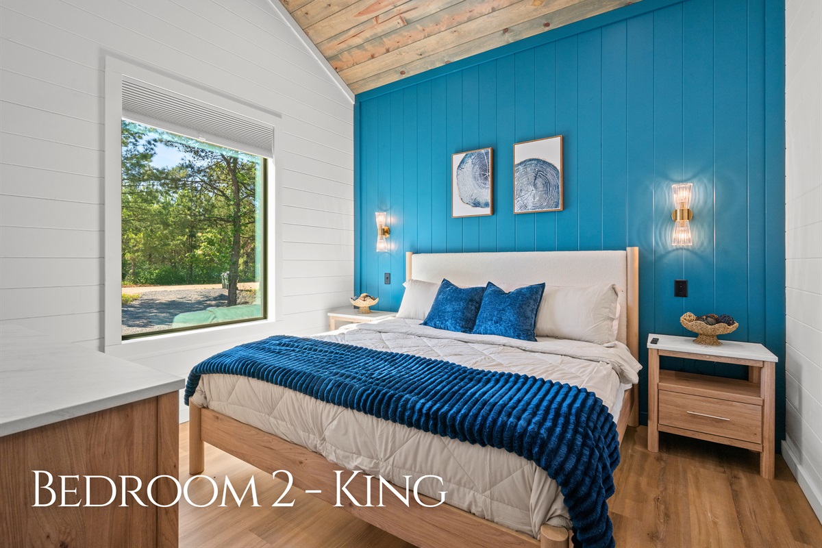 Rich blue accents, soft lighting, and cozy textures give this king bedroom a calm atmosphere that feels perfect for slowing down and relaxing.