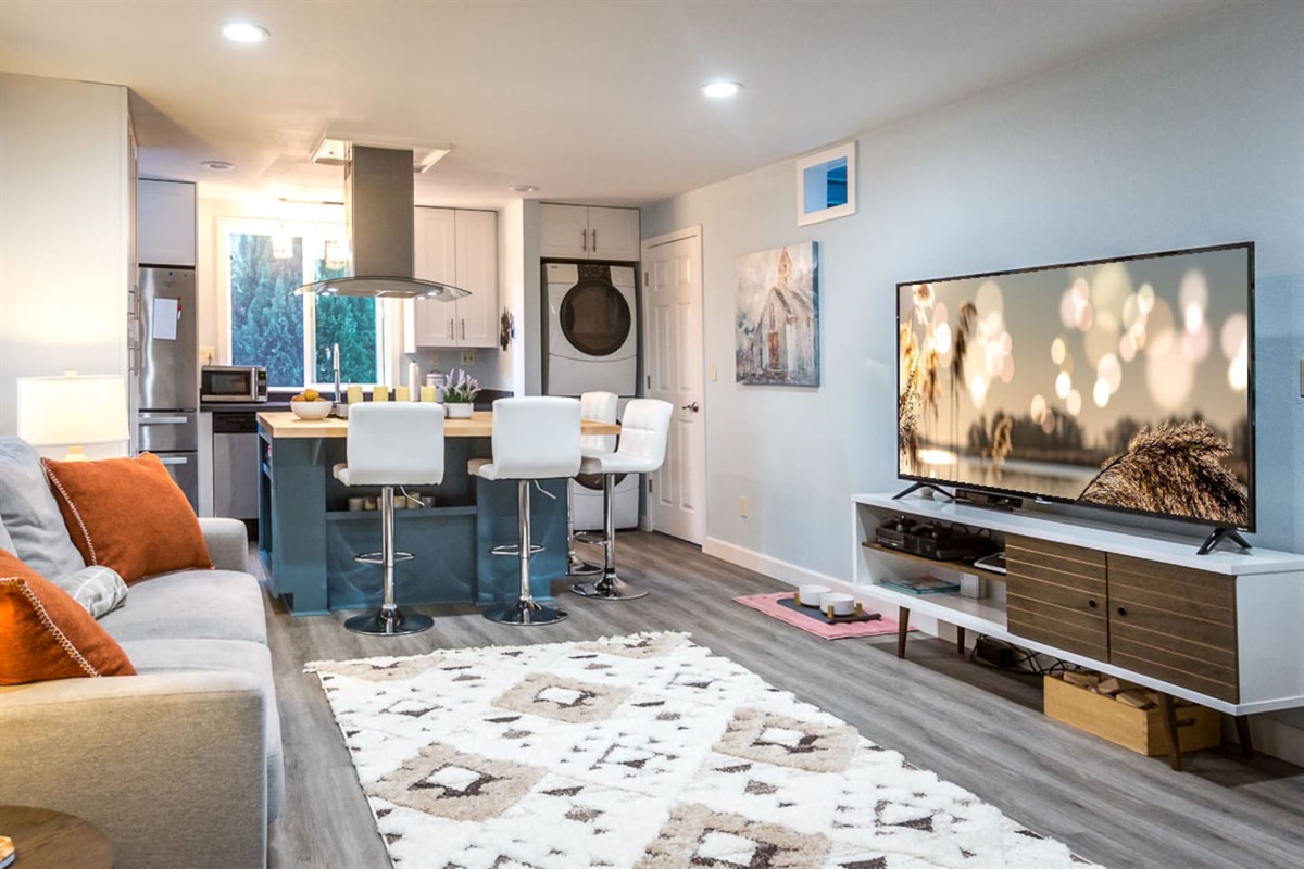 - Open plan living area seamlessly connecting kitchen, dining, & lounging zones
- Plush seating faces a flat screen TV for relaxing movie nights or casual viewing
- Island seating doubles as a spot for morning coffee or lively evening conversation