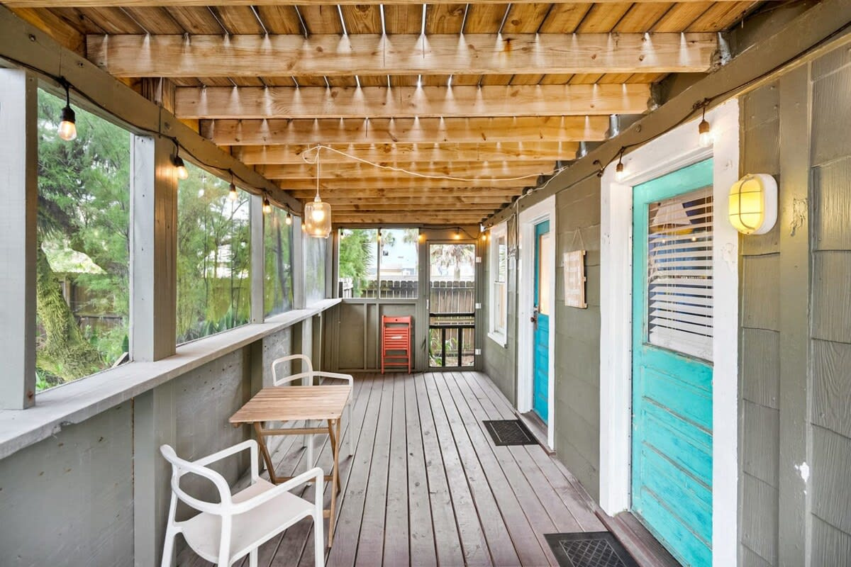 The screened porch runs along the back of the cottage, teal doors and all, catching the shade through the afternoon. Pull a chair up, prop your feet, and let the hours go by at a considerably slower pace.