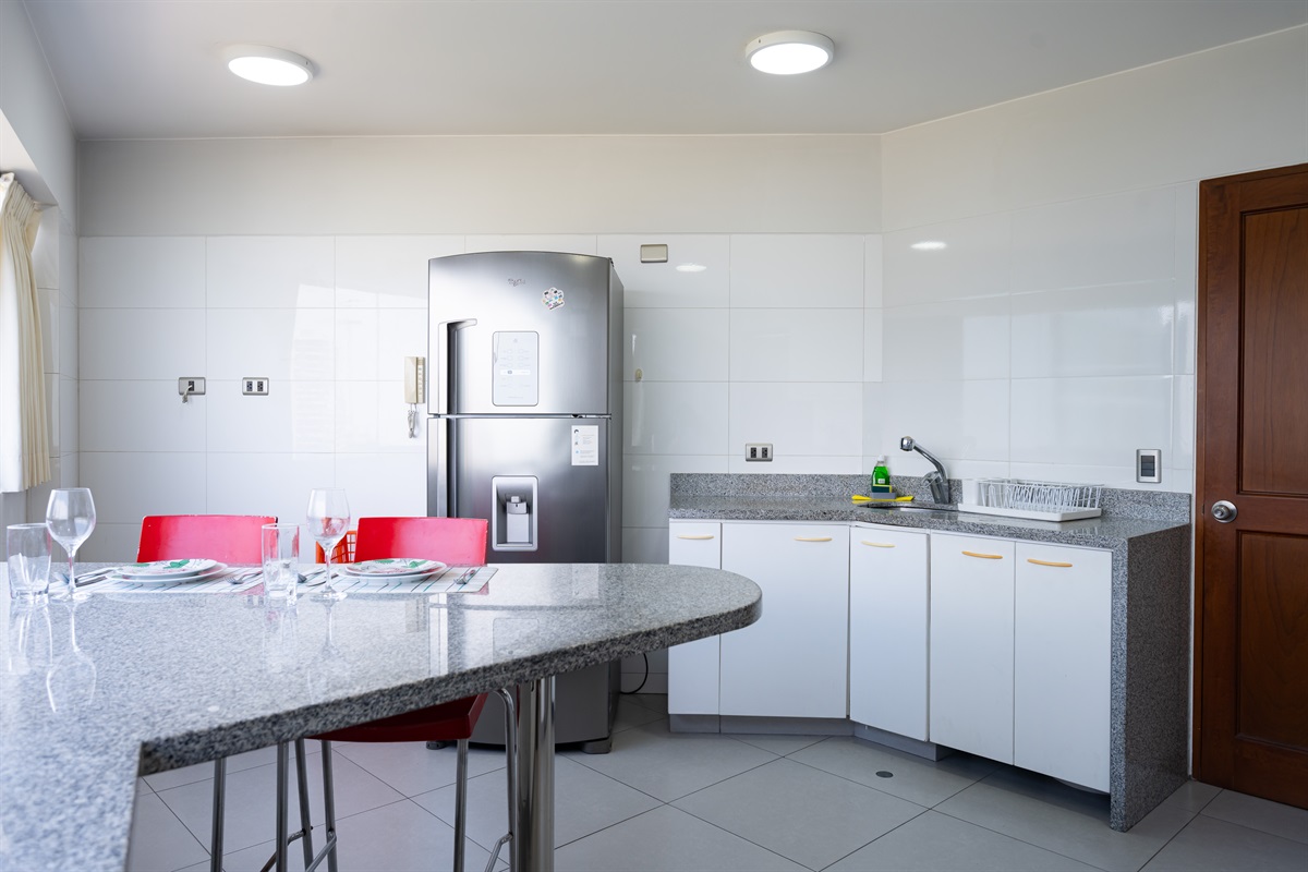 Fully equipped kitchen with electric stove, oven, large fridge, and everything you need to cook at home  /  Cocina totalmente equipada con estufa eléctrica, horno, refrigeradora grande y todo lo necesario para cocinar en casa