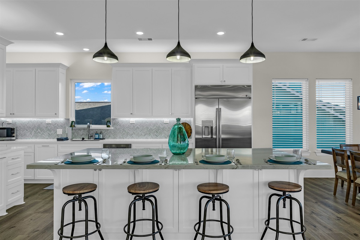 Costa Cristal Kitchen: Bright, modern kitchen with a large quartz island, stainless-steel appliances, and an open dining area perfect for group meals.