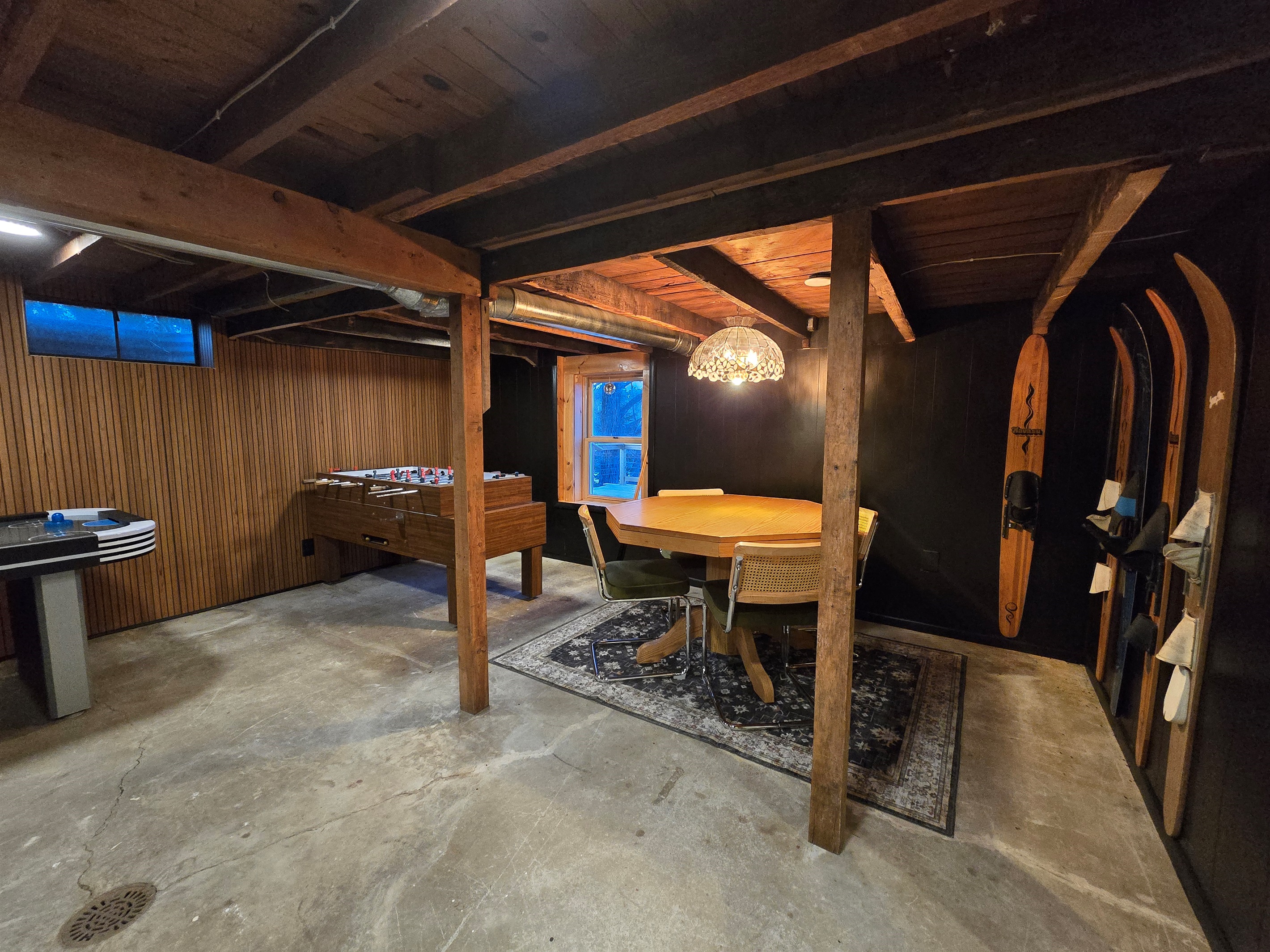Gather 'round the table under this stunning chandelier!  Enjoy games, snacks, and cozy vibes in our basement—skis ready for your winter adventure! 