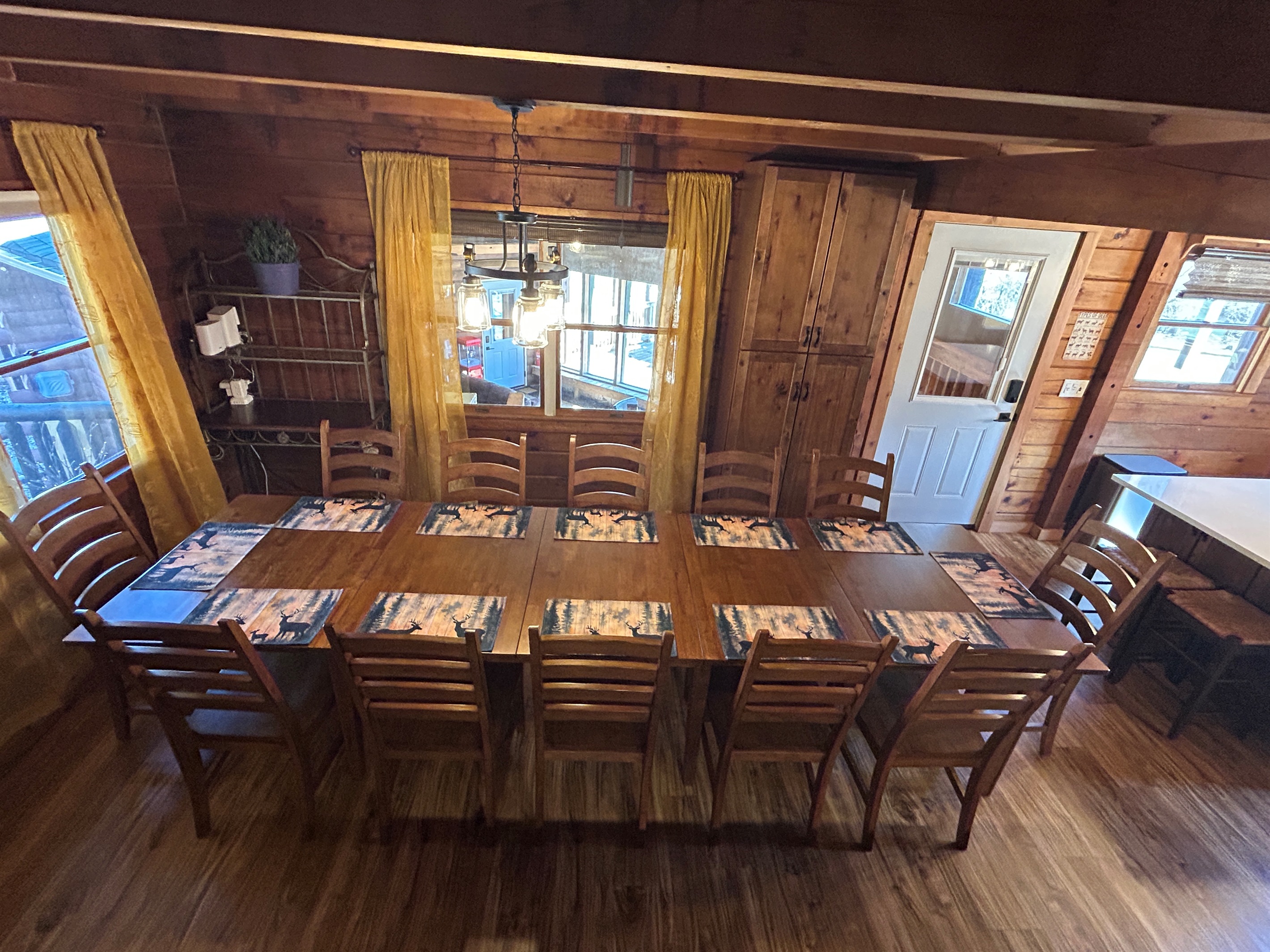 Everyone can eat meals together in the dining room. The bar stools at the kitchen island provide seats for those chatting with the cook. The door leads to the Sunroom.