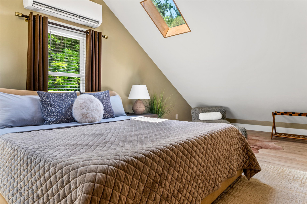 The Penthouse: Master Bedroom with King Bed, 42-inch Smart TV, Fireplace, sound machine, blackout curtains and cozy reading chair.