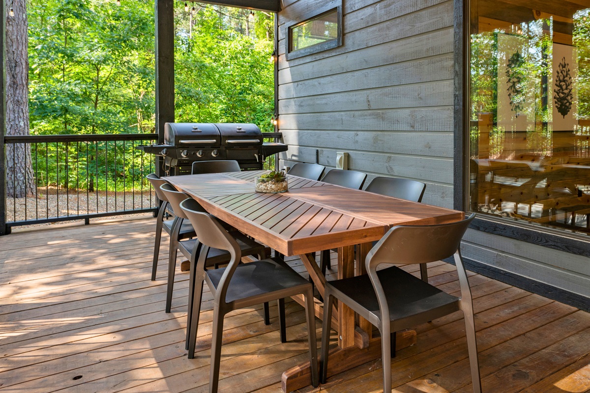 The spacious deck includes a modern outdoor dining area with a table and chairs