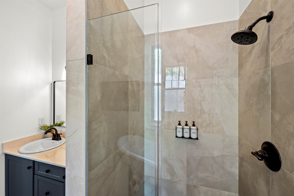 Step into this sleek, zero-entry tile shower with rainfall head and built-in luxury bath products—designed for comfort and accessibility.