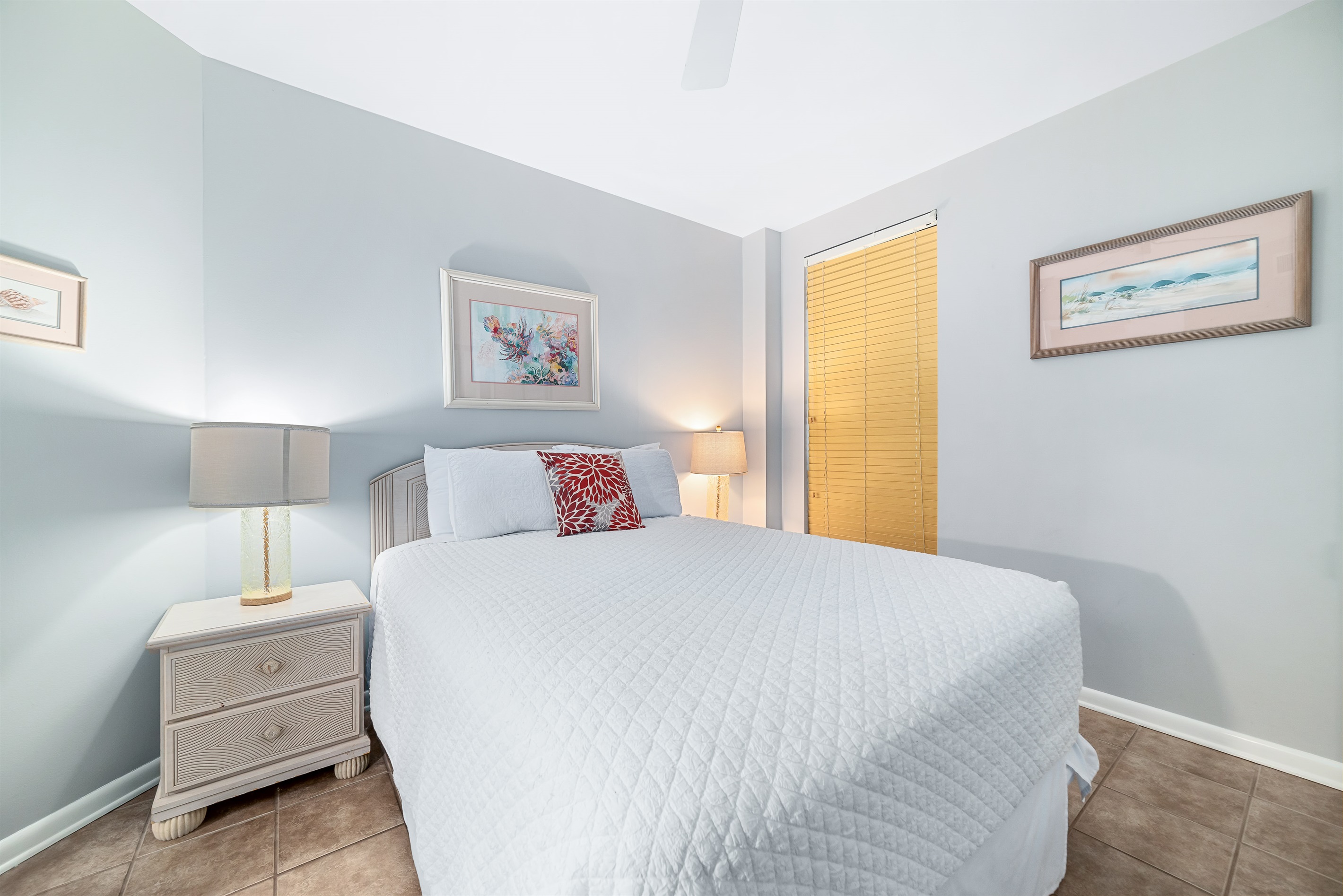 Relax in this bright and airy guest bedroom, featuring a comfortable queen-sized bed and subtle coastal accents.