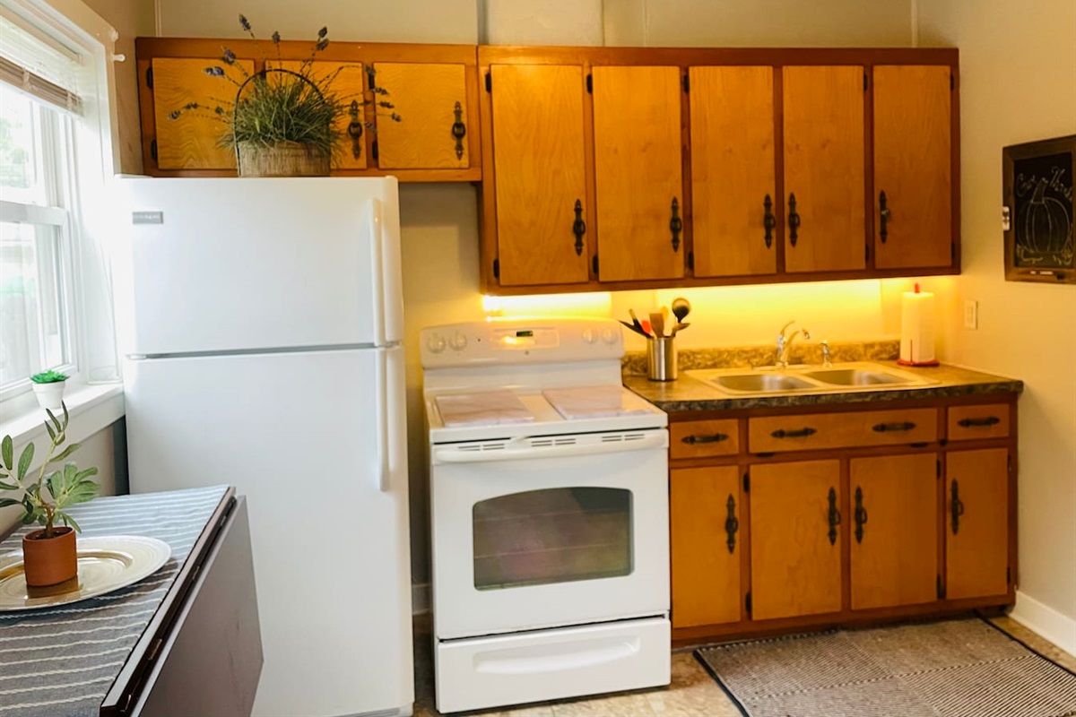 Kitchen is equipped with full size stove and good side fridge, plus under-cabinet lighting.