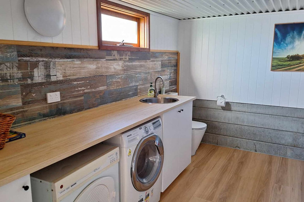 Fully equipped laundry with an extra toilet accessible from garden space
