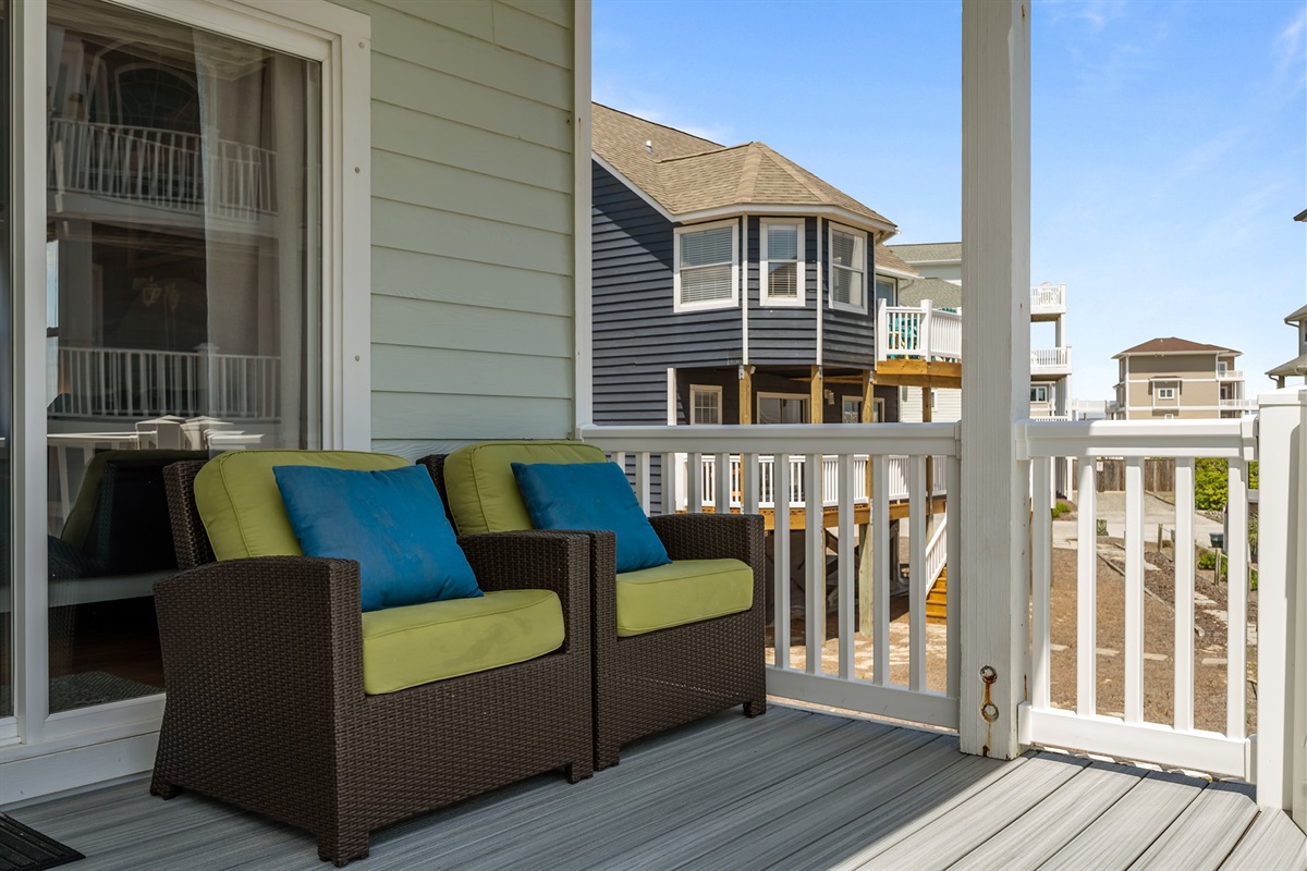 Spacious deck with a view of the beach and surrounding homes.