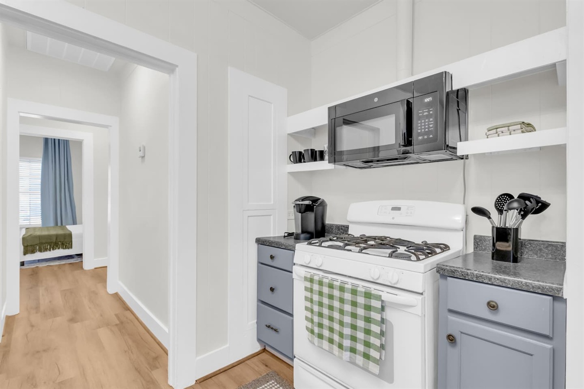 Bright full kitchen with ample counter space, storage, and all of the cooking basic and essentials.
