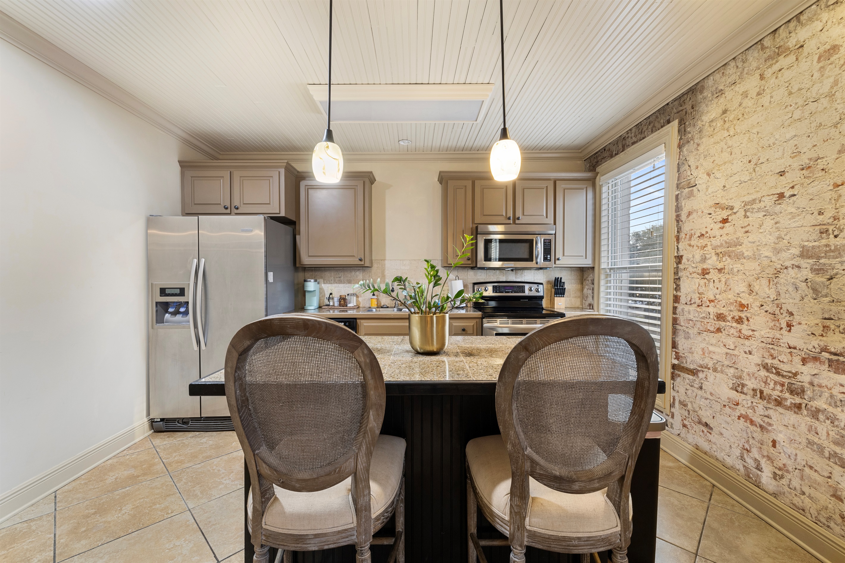 Modern appliances and a rustic brick backdrop invite culinary adventures