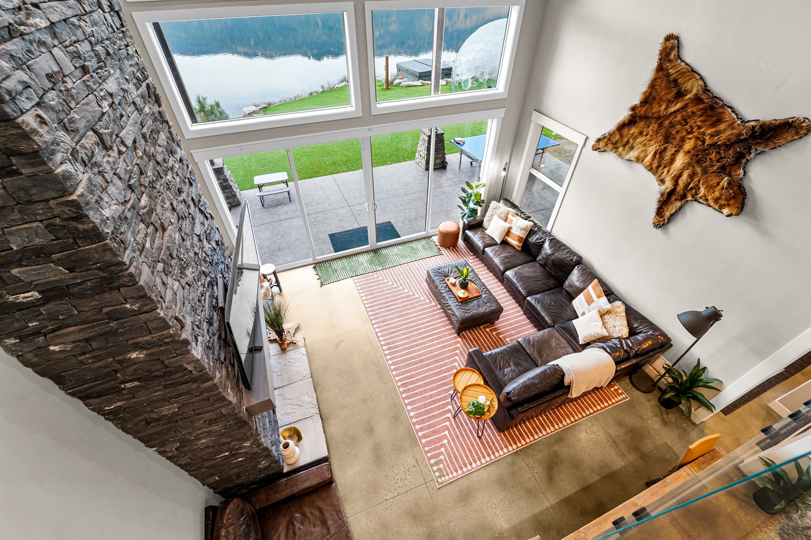 Spacious loft-style living room overlooks the serene private waterfront.