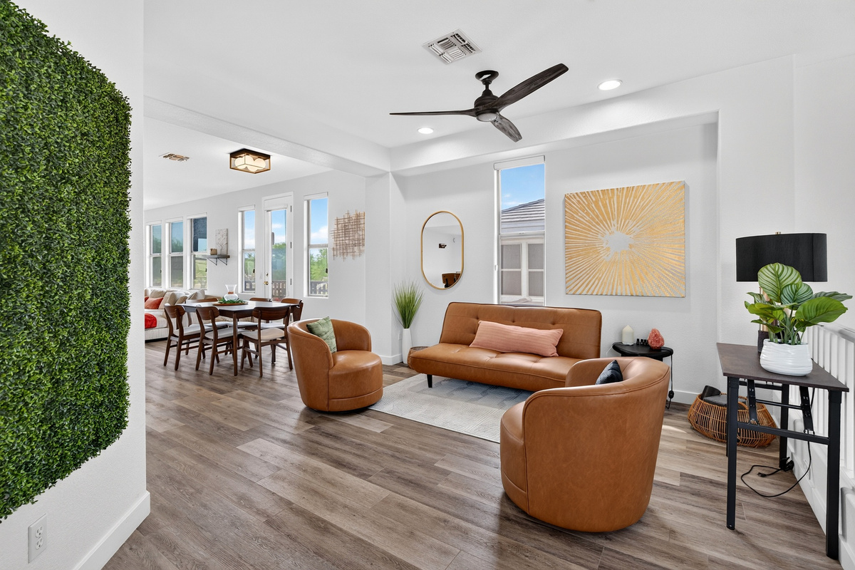 Open sitting area with accent chairs, sofa seating, natural light, and easy flow to the dining and living spaces.