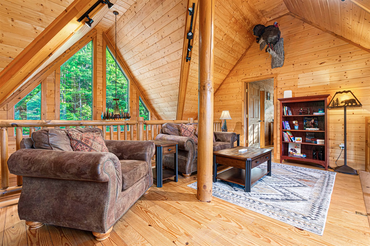 Upstairs Family Room: Nestle into the charming seating with stunning forest views through tall windows!