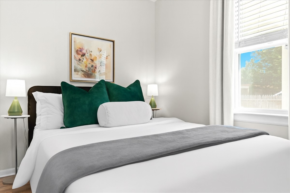 Inviting queen bedroom with fresh décor and nightstand lamps