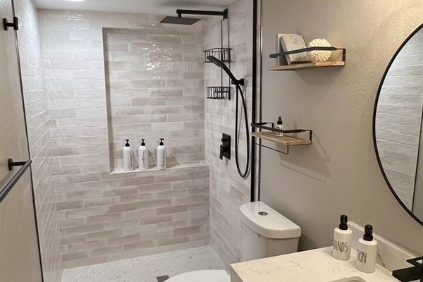 This full bathroom is located on the main floor, in the hallway between the kitchen and the primary bedroom. Since the upstairs has two bedrooms but one bathroom, this bathroom can also serve as the second bathroom for one of the upstairs bedrooms.