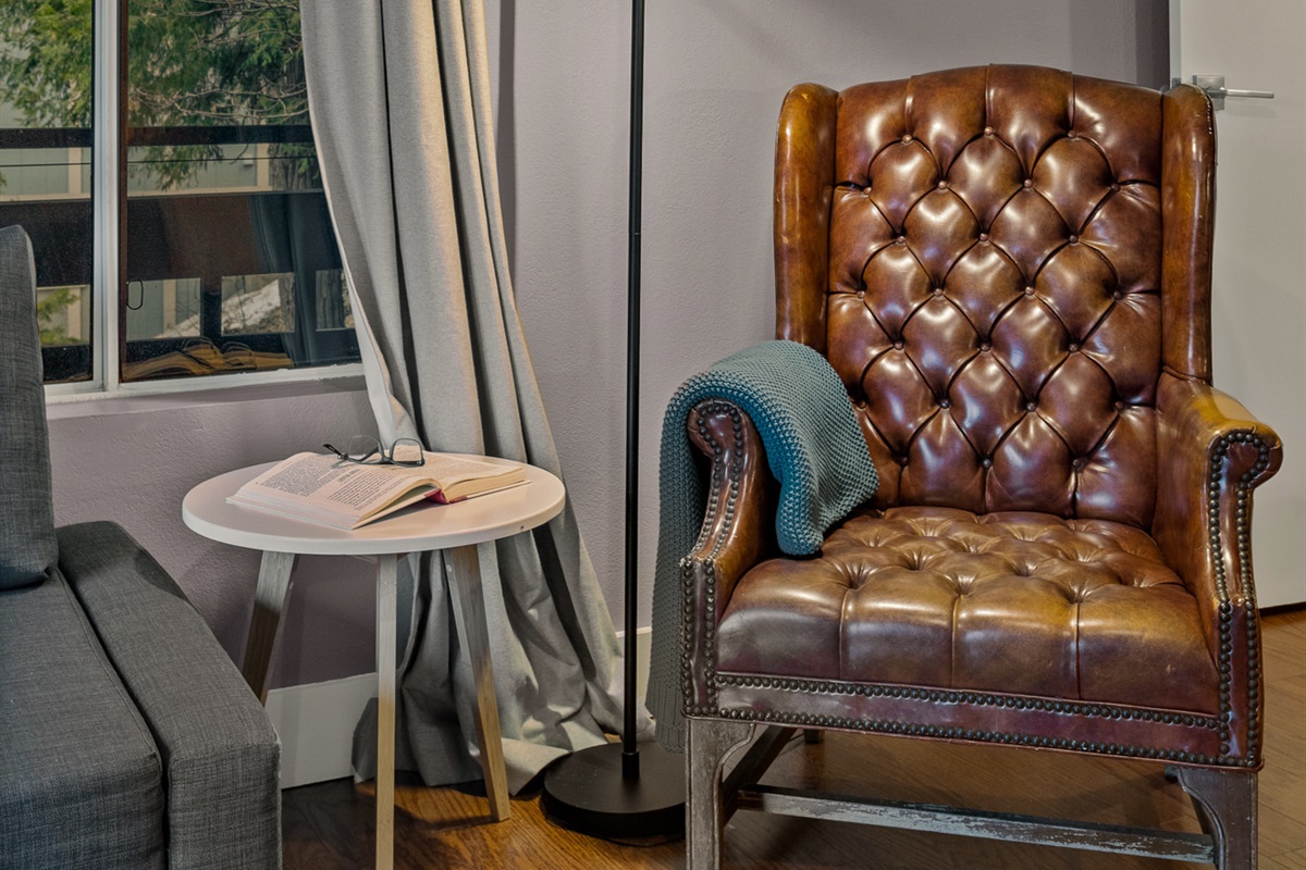 Cozy reading nook with a classic leather chair—perfect for unwinding with a book by the window.