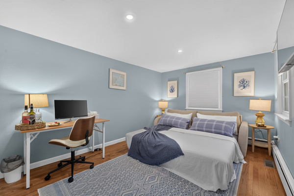 A relaxing retreat with cozy bedding and a functional workspace.