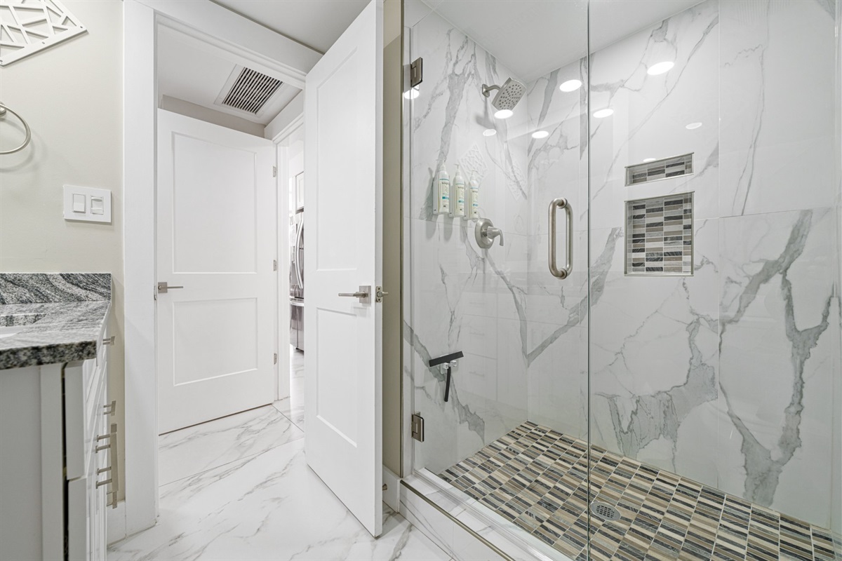 Marble from floor to ceiling, frameless glass, and brushed nickel hardware throughout. This master bath is the kind of bathroom that resets your expectations for what a vacation rental can be.
