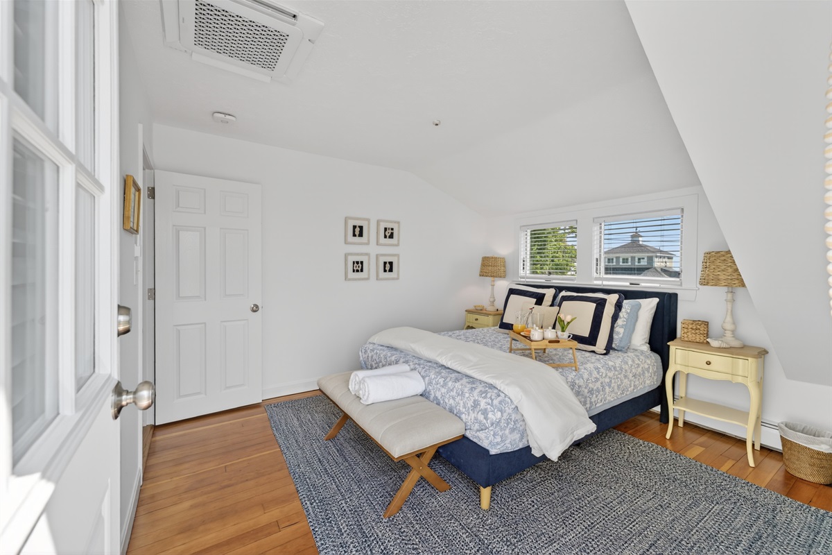 Bright queen bedroom with easy bathroom access and direct entry to the second-floor deck.