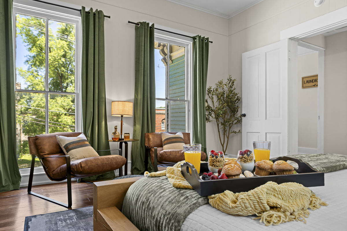 Bright and airy with sage green curtains, a leather sitting chair, and windows that let the Kentucky morning pour in.
