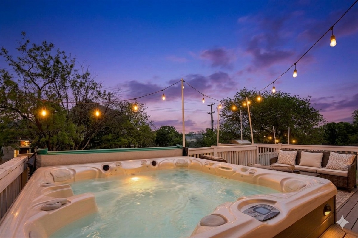 Relax in the warm hot tub under soft string lights—perfect for a peaceful, cozy night.