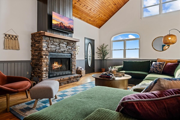 Vaulted ceilings and a wall of windows frame endless mountain views as your group gathers on the oversized sectional. Cozy up by the fireplace or step out to the decks—this is the heart of the home.
