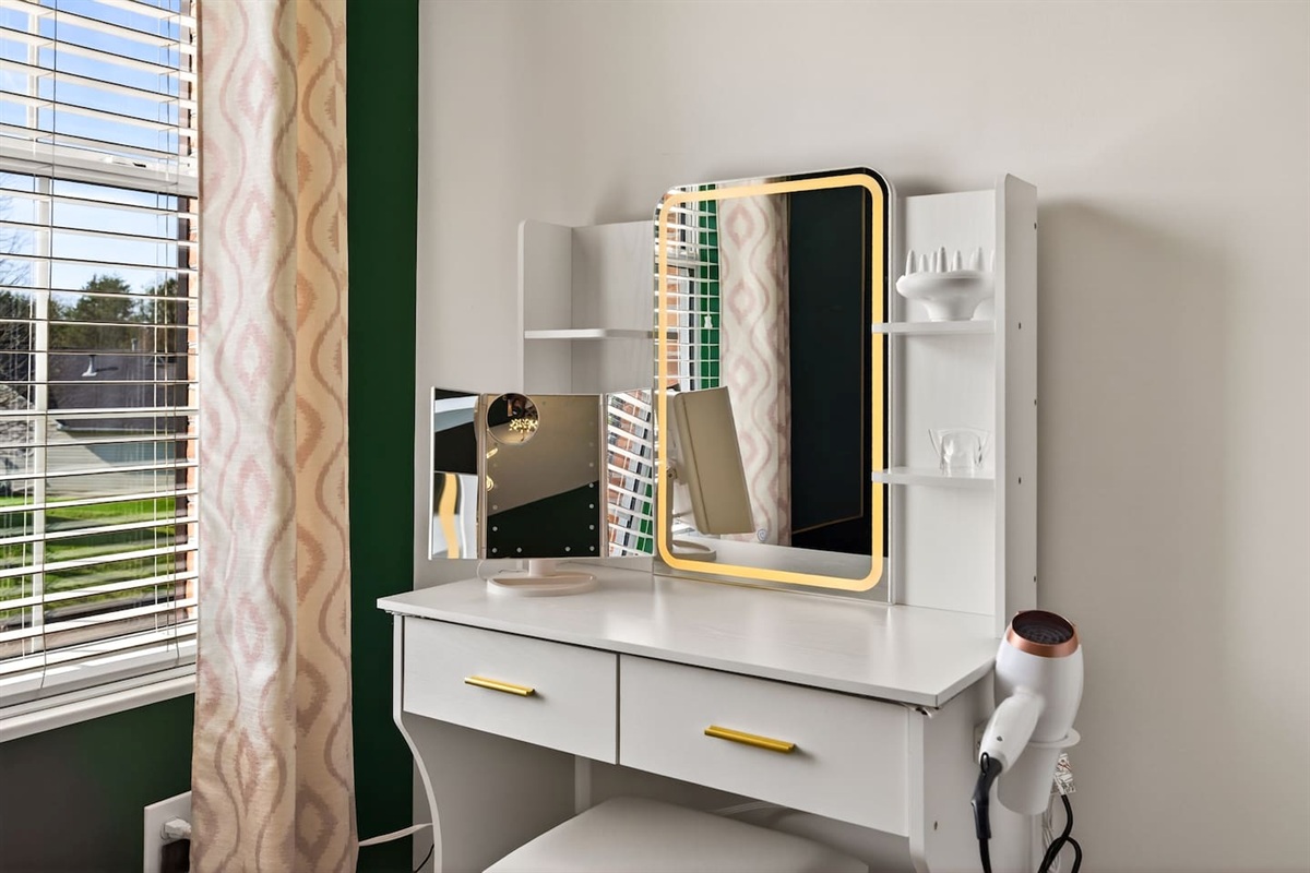 Additional vanity with lighted mirror.