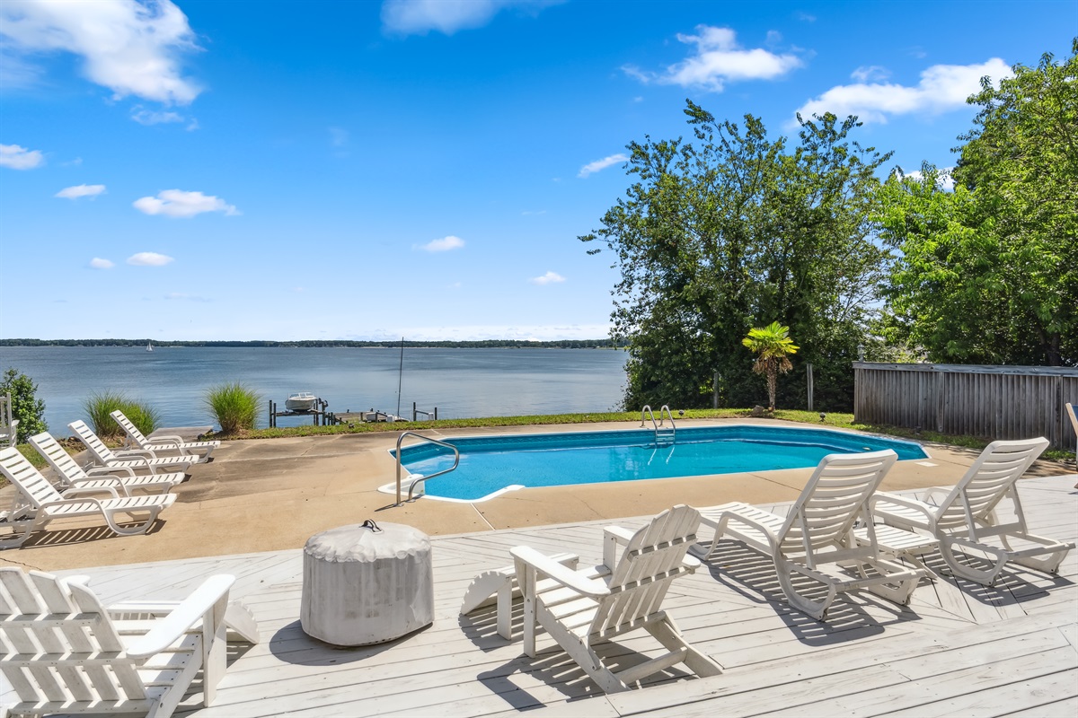 Private waterfront pool with open views and comfy loungers—ideal for swimming and unwinding.