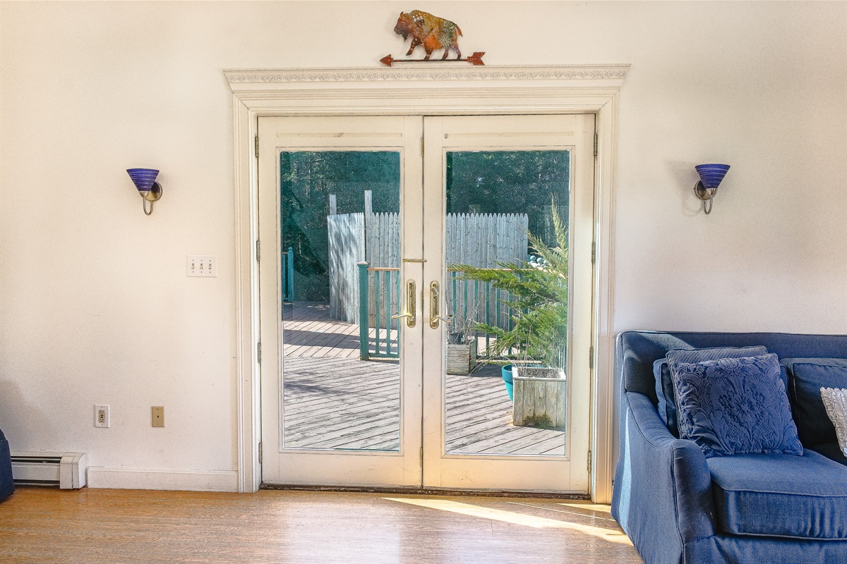 Step outside through elegant French doors to the expansive back deck. This seamless transition from the living room to the outdoors makes it easy to enjoy the fresh Maine air and private wooded views at your Southwest Harbor estate.