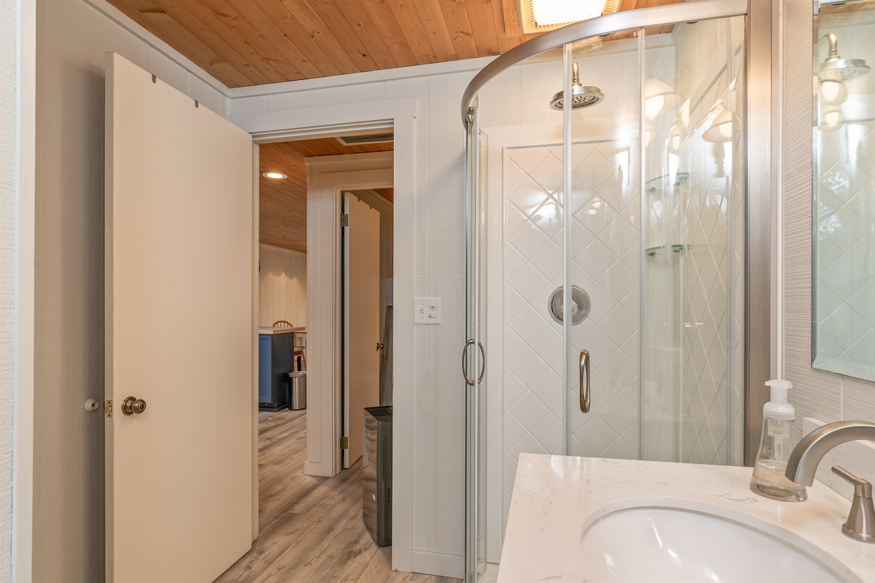 Spacious walk-in shower with glass doors and warm lighting for a spa-like feel.