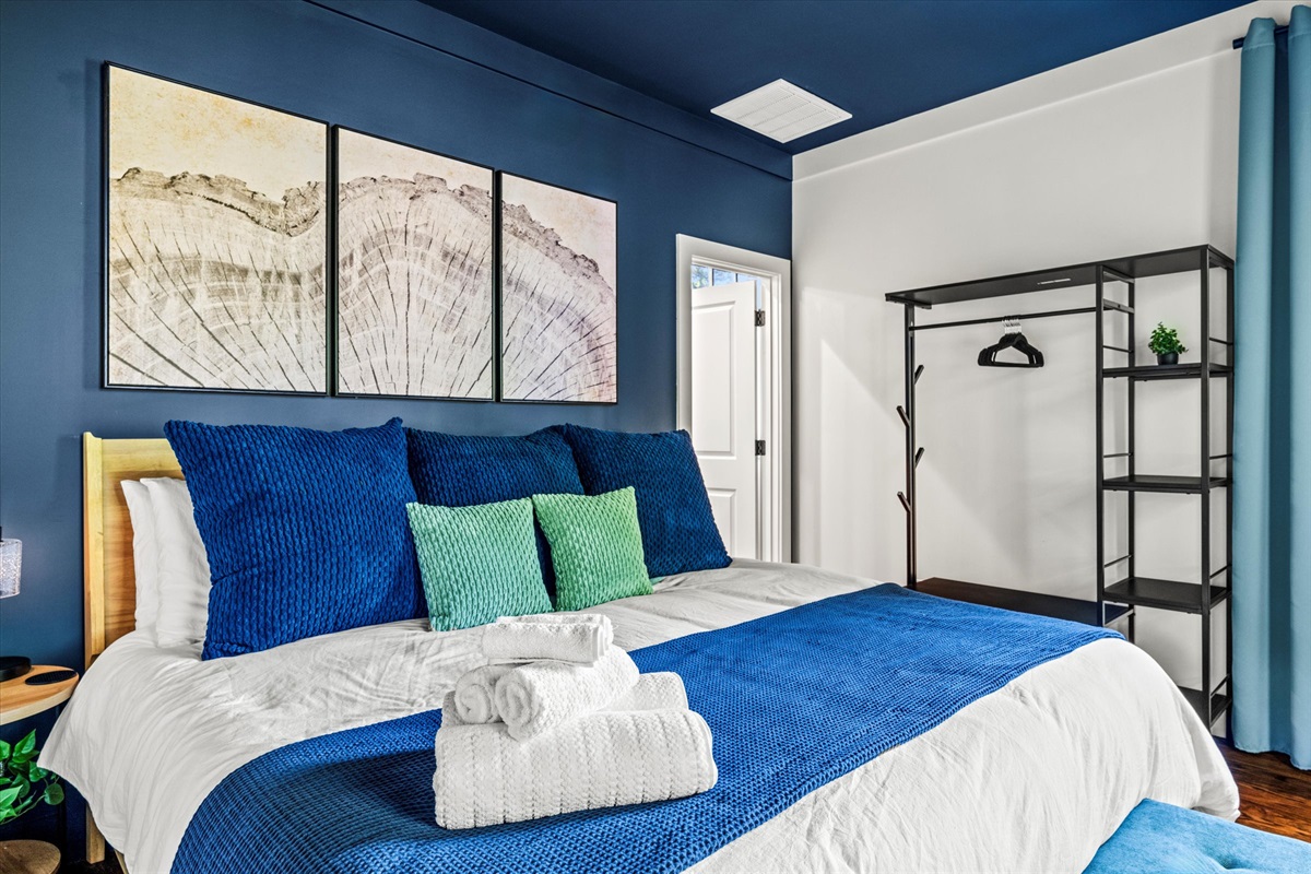 Bold colors meet calm vibes in this spacious king suite, where rich navy walls and forest views create the perfect backdrop for deep rest and morning light.