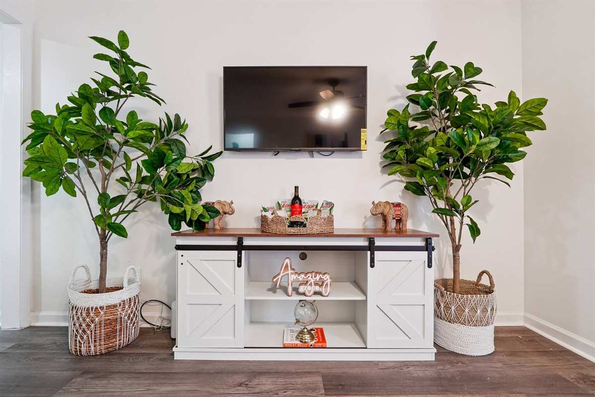 The living room features cozy furniture, including a comfortable blue couch, and an Amazon Fire-powered Smart TV for your entertainment. You’ll also find the Xfinity modem conveniently located here, convenient for ethernet connection.