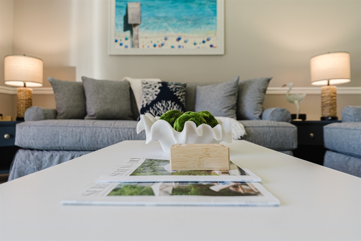 Bright and spacious coastal-inspired living room with oversized seating, Smart TV, cable, and direct access to the patio and outdoor dining area.
