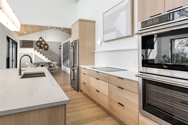 This sleek, modern kitchen is fully equipped with high-end appliances and spacious countertops for preparing group meals with ease. 