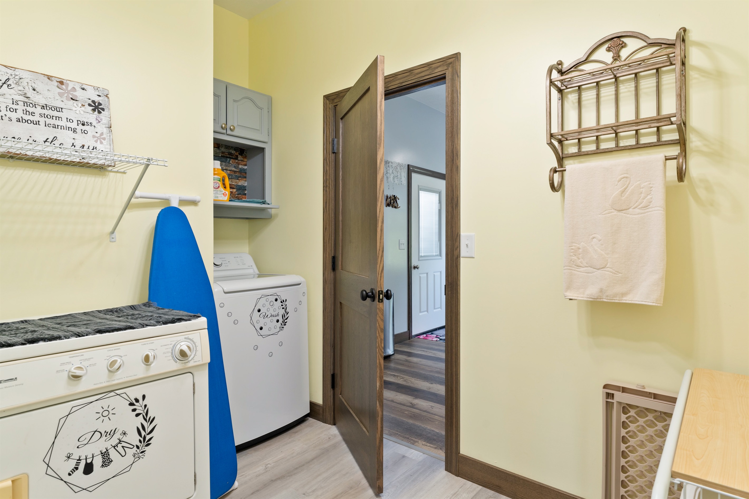 Functional laundry room with washer, dryer, shelving, and rustic accents for added charm.