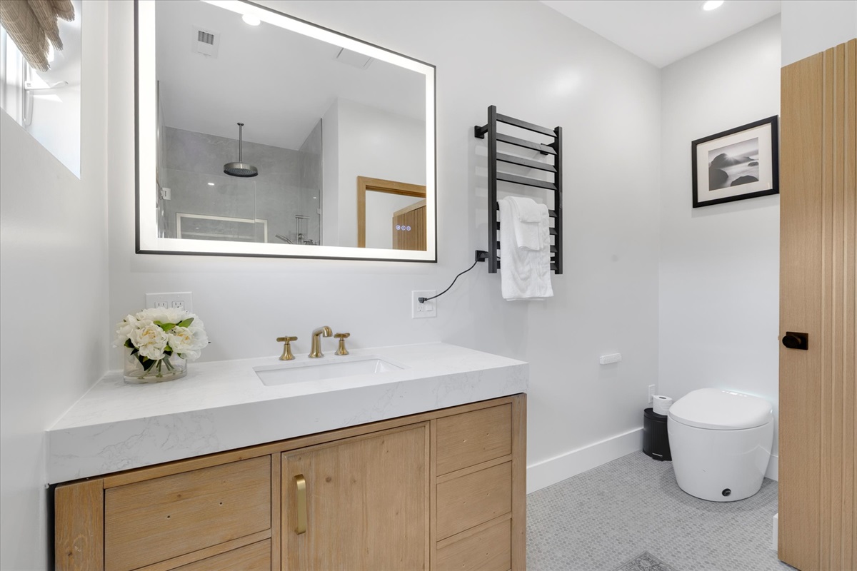 Bathroom for this bedroom with towel rack warmer and rain shower.