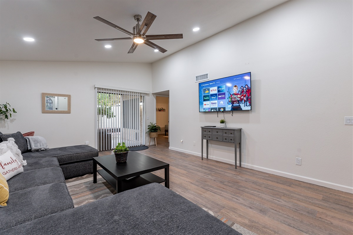 The main room with large 4k mounted tv, sliding door to backyard and open to dining and kitchen.