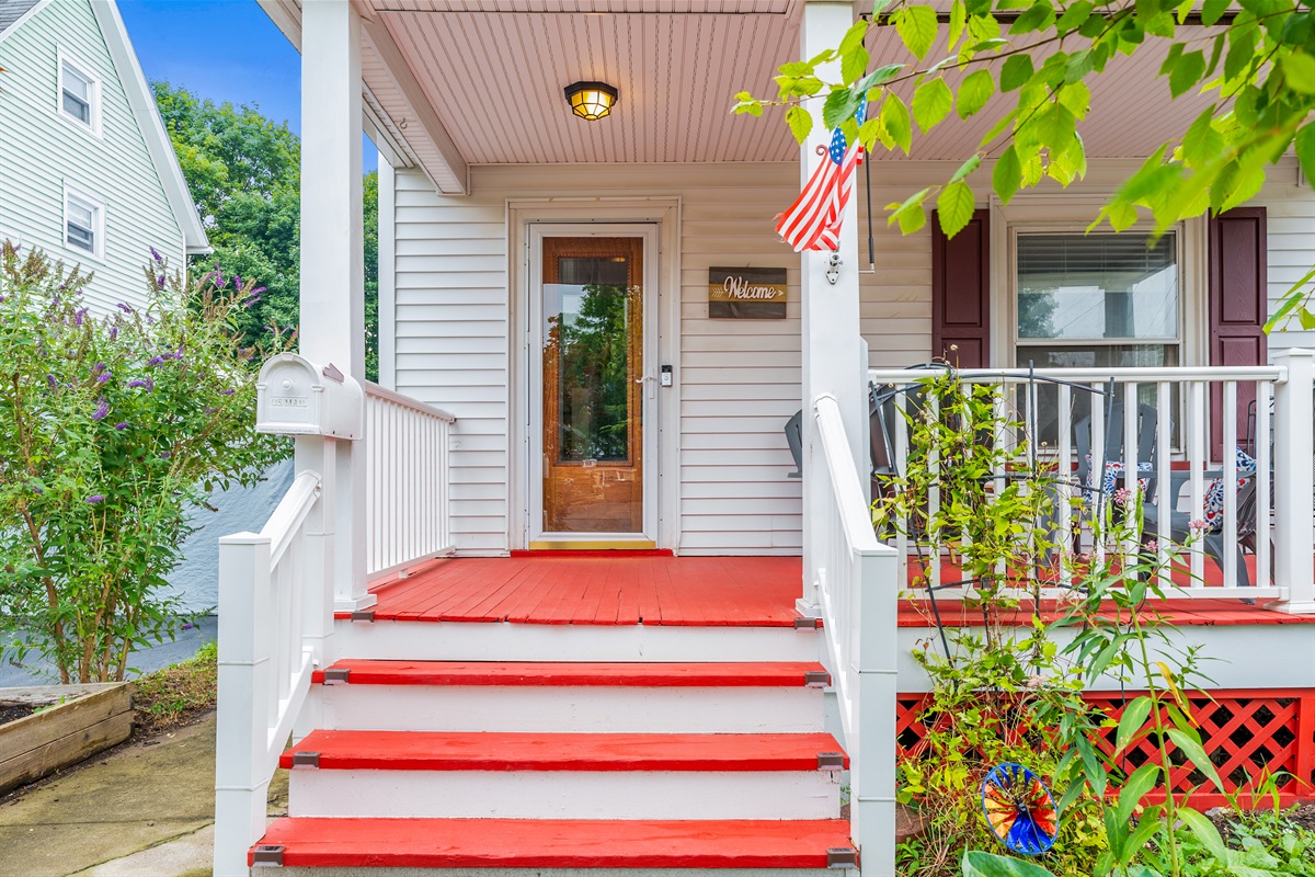Step into warmth and hospitality with a vibrant red entryway and a cozy "Welcome" sign that sets the tone.